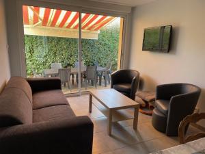 a living room with a couch and chairs and a table at BAIE MT ST MICHEL VILLA Caprice Rdc 50 m Mer Prés Plage DDAY 7pers in Jullouville-les-Pins