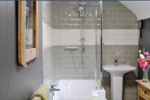 uma casa de banho com um chuveiro e um lavatório. em Woodbank Cottage Newton Stewart em Newton Stewart