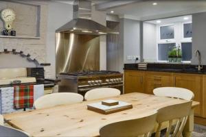 a kitchen with a wooden table and a stove at Woodbank Cottage Newton Stewart in Newton Stewart