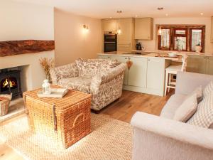 a living room with a couch and a table and a kitchen at 11 Lane End in Bradford