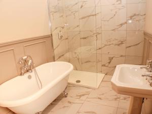 a bathroom with a tub and a shower and a sink at 11 Lane End in Bradford