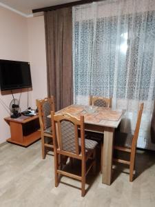 a dining room table with chairs and a television at Jovanovic in Topola