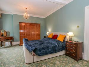 1 dormitorio con 1 cama, vestidor y escritorio en Plas Cerrig Hall, Crossways Road en Mold
