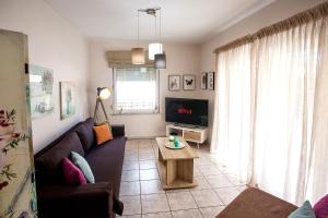 a living room with a couch and a table at Holiday House Ioanna in Nea Peramos