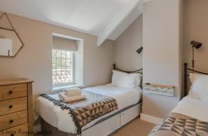 a small bedroom with two beds and a window at Duck Cottage - Grade II Listed cottage, village location, nr Holt in Letheringsett