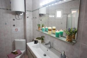 a bathroom with a sink and a toilet and a mirror at Holiday House Ioanna in Nea Peramos +39 photos