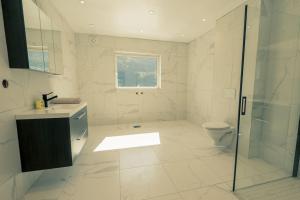 La salle de bains est pourvue d'une douche, d'un lavabo et de toilettes. dans l'établissement Modalen Fjord Cottage, à Mo