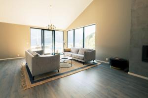 a living room with two couches and a table at Modalen Fjord Cottage in Mo