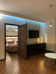 sypialnia z łóżkiem, telewizorem i stołem w obiekcie Holiday Apartments Browar Lubicz Krakow Stare Miasto w Krakowie