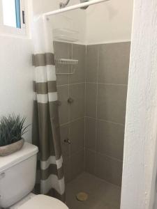 a bathroom with a shower with a toilet and a shower curtain at Casa Monik, a dos pasos de la Playa in Cancún +35 photos
