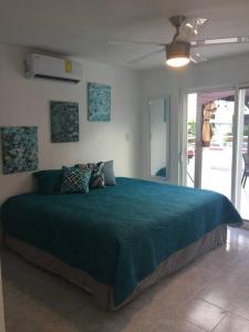 a bedroom with a large bed with a blue blanket at Casa Monik, a dos pasos de la Playa in Cancún