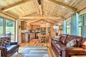 uma sala de estar com sofás de couro e uma cozinha em Clover Cabin with Hot Tub and Deck in Hocking Hills! em Logan