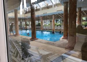 a swimming pool with white chairs in a building at Green Park in Punta del Este