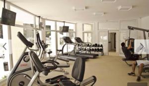 a gym with several cardio machines in a room at Green Park in Punta del Este