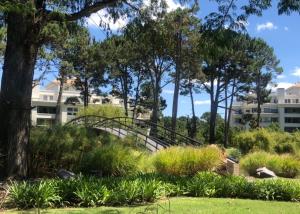 a bridge in a park with trees and grass at Green Park in Punta del Este