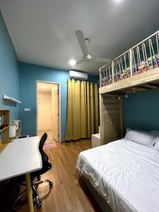 Lapan Ompek Homestay 3 Bedrooms في نيلاي: غرفة نوم مع سرير ومكتب وسرير بطابقين