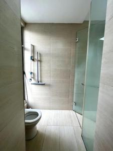 ニライにあるLapan Ompek Homestay 3 Bedroomsのバスルーム(トイレ、ガラス張りのシャワーブース付)