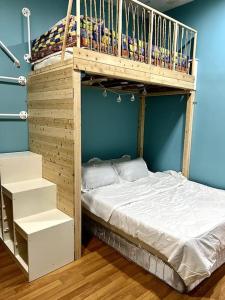 Ce lit superposé en bois se trouve dans un dortoir doté d'un lit. dans l'établissement Lapan Ompek Homestay 3 Bedrooms, à Nilai