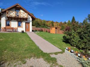 a house with a pathway in front of a yard at Słoneczna Chałupka in Zawoja