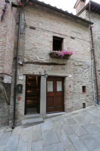 ein Backsteingebäude mit einer Tür und einem Fenster mit Blumen in der Unterkunft Casina Iannelli in Cortona
