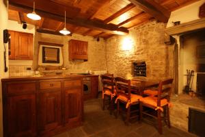 una cocina con armarios de madera, mesa y sillas en Casina Iannelli, en Cortona