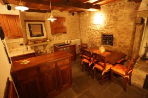 y cocina con mesa de madera, sillas y fogones. en Casina Iannelli, en Cortona