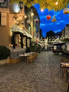 uma rua de calçada com mesas e restaurantes à noite em Boutique Guest House Coco em Plovdiv