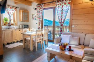 a kitchen and living room with a table and a couch at Osada Brzezia in Kluszkowce