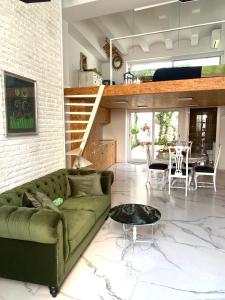 a living room with a green couch and a table at Loft con mucha luz en el centro Barrio Ruzafa in Valencia