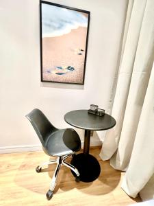 a black chair and a table in a room at Flat novo, 2 quartos, garagem no coração dos Jardins in São Paulo
