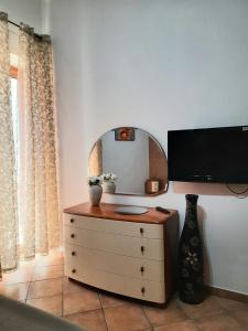 波佐利的住宿－MOONLIGHT HOUSE，客房设有带镜子的梳妆台和电视。