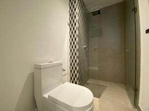 een badkamer met een wit toilet en een douche bij Apartaestudio Amoblado - Distrito90 in Barranquilla