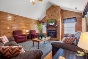 uma sala de estar com paredes de madeira e uma lareira em Poplar Point Condo Unit 12B em Pigeon Forge