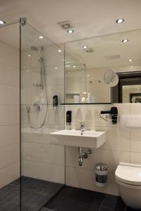 a bathroom with a sink and a shower and a toilet at Arthotel Munich in Munich