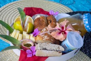 uma cesta de comida com pão, pastelaria e flores em T3 moderne au cœur du village em Ouangani