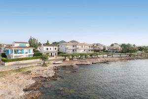 un grupo de casas junto a un cuerpo de agua en SES ONES with sea views, en Alcudia