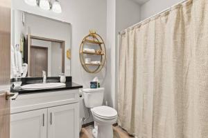 a bathroom with a toilet and a sink and a mirror at Brand New 2 Bed 2 Bath Near Perry District and DT in Spokane