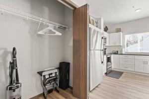 Il comprend une cuisine équipée d'un réfrigérateur blanc et du parquet. dans l'établissement Brand New 2 Bed 2 Bath Near Perry District and DT, à Spokane