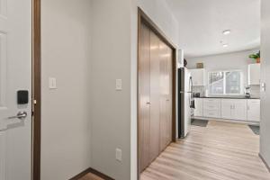 une cuisine avec des murs blancs et une porte en bois dans l'établissement Brand New 2 Bed 2 Bath Near Perry District and DT, à Spokane 17 autres photos