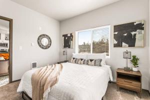 ein weißes Schlafzimmer mit einem Bett und einem Fenster in der Unterkunft Brand New 2 Bed 2 Bath Near Perry District and DT in Spokane