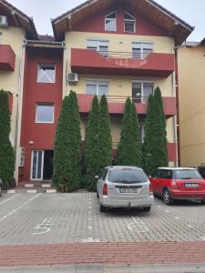 dois carros estacionados num parque de estacionamento em frente a um edifício em Apartament Mara em Alba Iulia