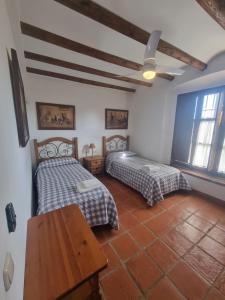 a bedroom with two beds and a wooden table at Finca exclusiva (10.000m2) para 10-17 personas in Seville