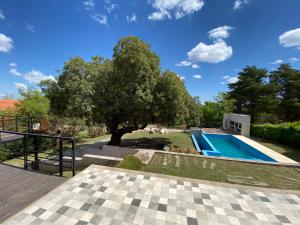a house with a swimming pool and a tree at Andelka-Chumamaya Merlo San Luis in Merlo