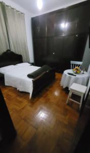 a bedroom with a bed and a table and a chair at Recanto Esperança - Na Feirinha do Alto in Teresópolis