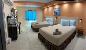 Cette chambre comprend deux lits et une télévision. dans l'établissement Aqua by Dreams Hotel, 