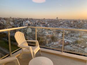 a balcony with two chairs and a view of a city at Rent a Flat in Cordoba