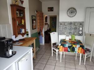 a kitchen with a table and chairs and a clock on the wall at Cute 1-bed cottage with view across park. in Issac