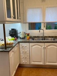 a kitchen with white cabinets and a sink at Casa Veuràs Girona - Montilivi in Girona