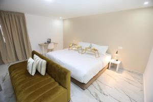 a bedroom with a white bed and a couch at MJI GROUP in Tan-Tan +44 photos