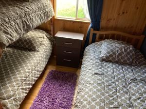 1 dormitorio con 2 camas y ventana en Cabañas Río Quemille en Huillinco